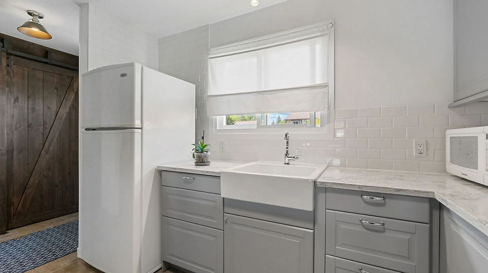 Humble Creek Construction custom L shaped kitchen layout remodel featuring white appliances stainless steel range hood and quartz countertops Carp