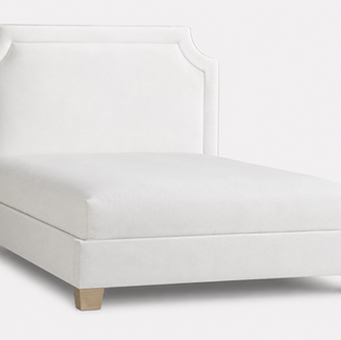 White upholstered bed with a curved headboard