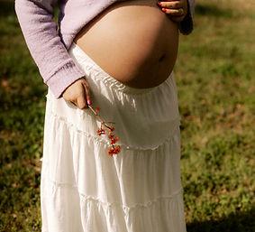 Pregnant woman in a white skirt holding