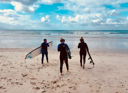 A group of friends heading out to surf in South Africa