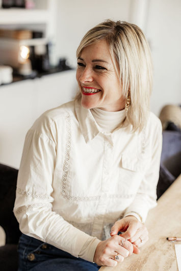 Lachend, sitzend am Tisch, nach links schauend