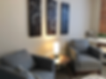 Waiting area with comfy gray chairs and wall art.