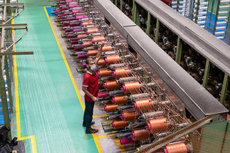 Factory production line with industrial machinery and workers photographed during manufacturing operations.