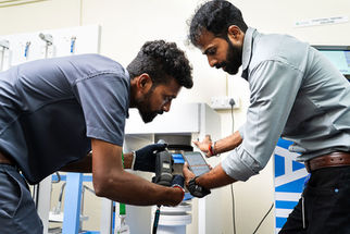 Engineers performing machinery inspection inside a manufacturing facility.