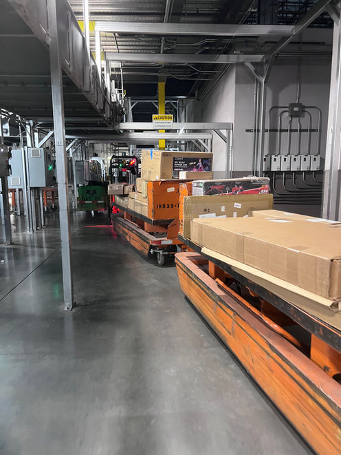 Interior photograph of a UPS automated distribution center showing loaded package carts moving through an industrial logistics corridor.