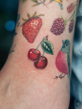tatuagem colorida de cerejas feita por Gabriela Dássio tatuadora em São Paulo