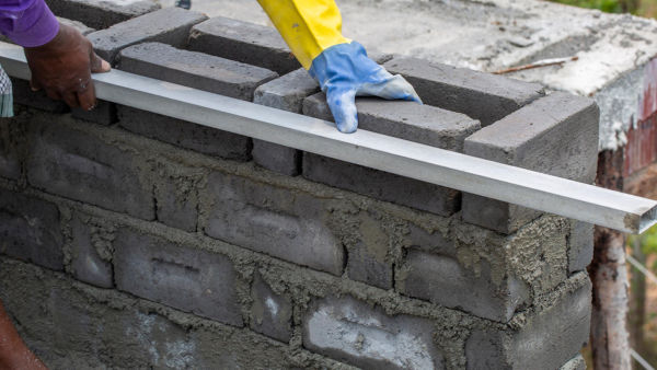 A construction worker installing fly ash bricks