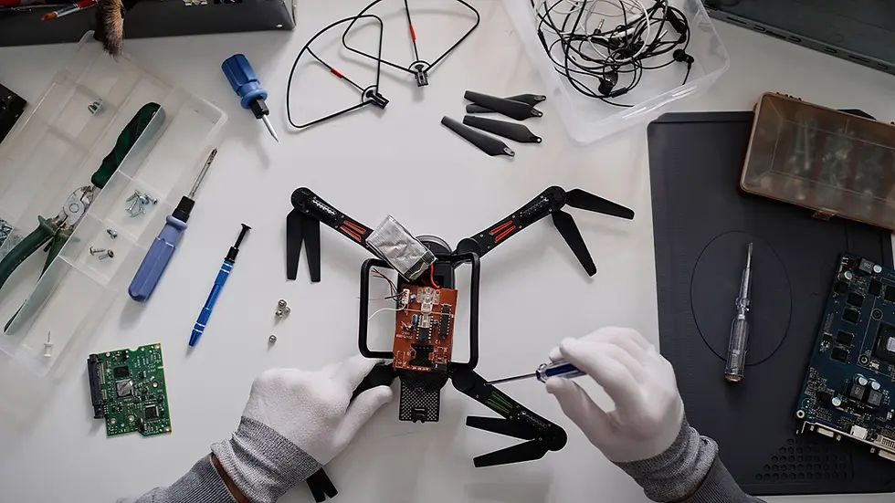 Technician assembling a drone PCB on a workbench with tools and components