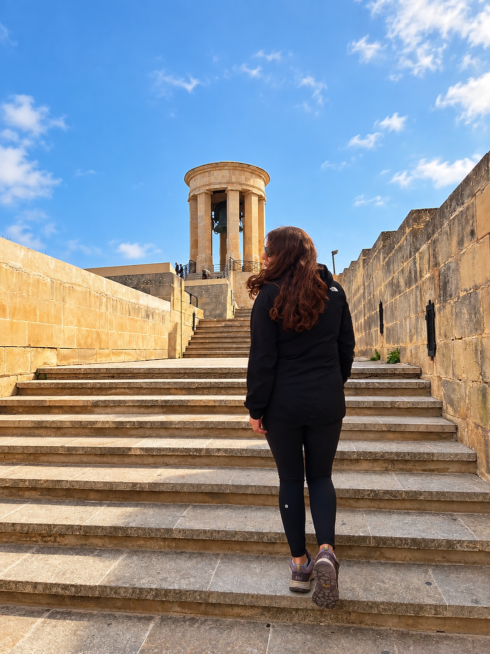Mujer subiendo escaleras hacia monumento en Malta