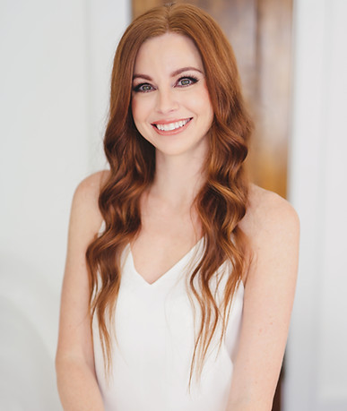 Professional photo of Jaime Smithers, founder of Pure Aesthetics SRQ, beautiful redhead woman with long hair and blue eyes smiling