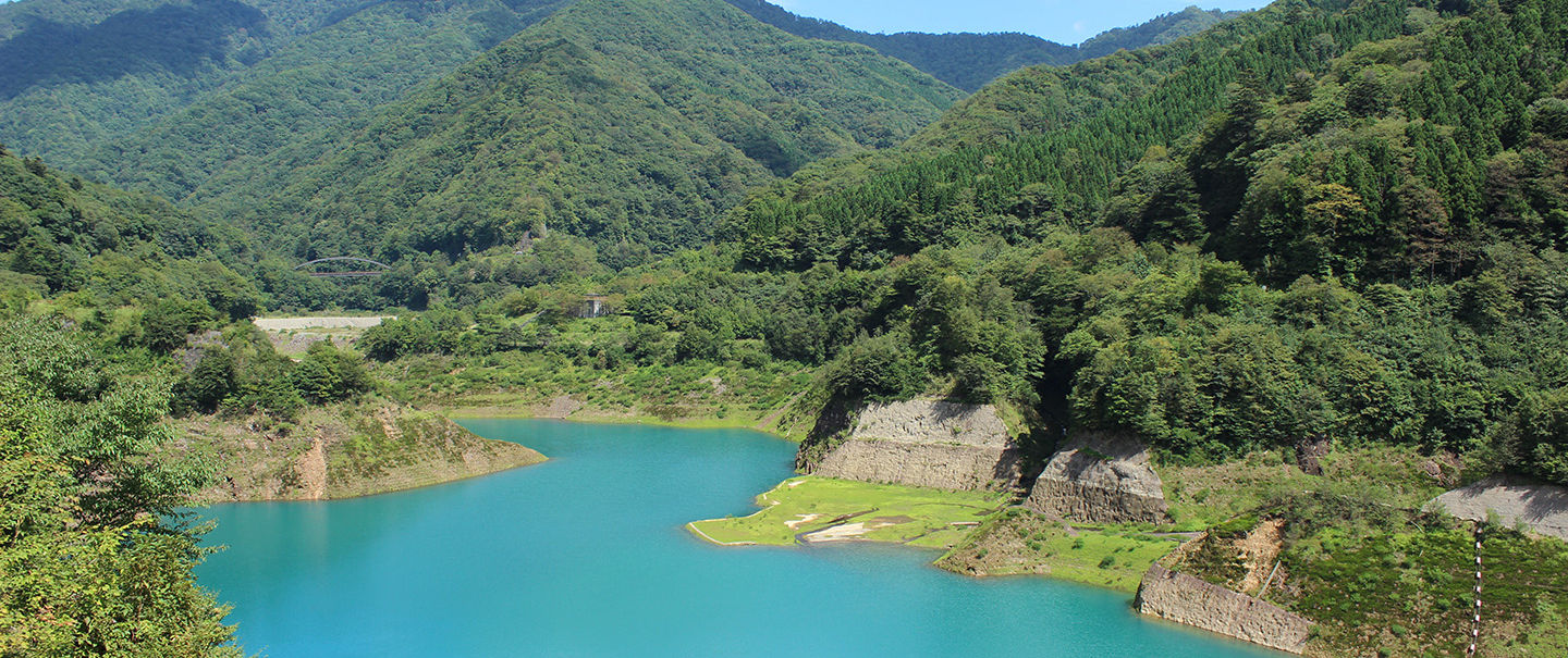Cobalt blue waters of Lake Okushima surrounded by mountains near Shima Onsen