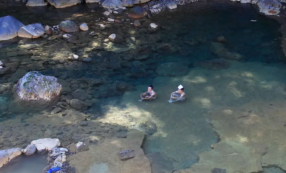 Traditional outdoor hot spring bath surrounded by nature in Gunma
