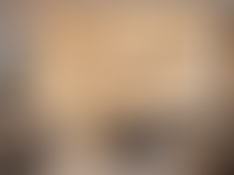 Luxurious living room with beige sofas, armchairs, and a round coffee table. Marble wall with warm lights, minimalistic decor, cozy mood.