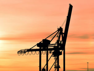 Grúa portacontenedores a contraluz al atardecer