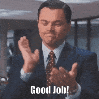 Man in a suit claps hands with a slight smile in an office setting. "Good Job!" text overlays the bottom of the image, conveying approval.