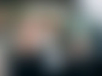 Femme portant un masque de protection à l’intérieur d’une voiture, utilisant un spray désinfectant pour assainir l’habitacle et éliminer les mauvaises odeurs.