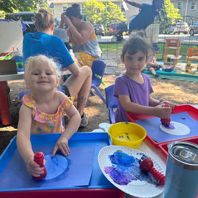 children playing at outdoor craft tables