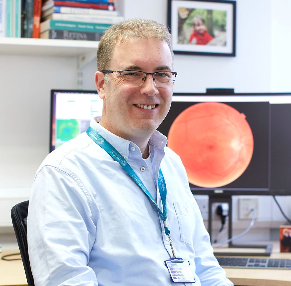 Photo of Pearse Keane against the backdrop of a computer screen, which displays a colour fundus photograph