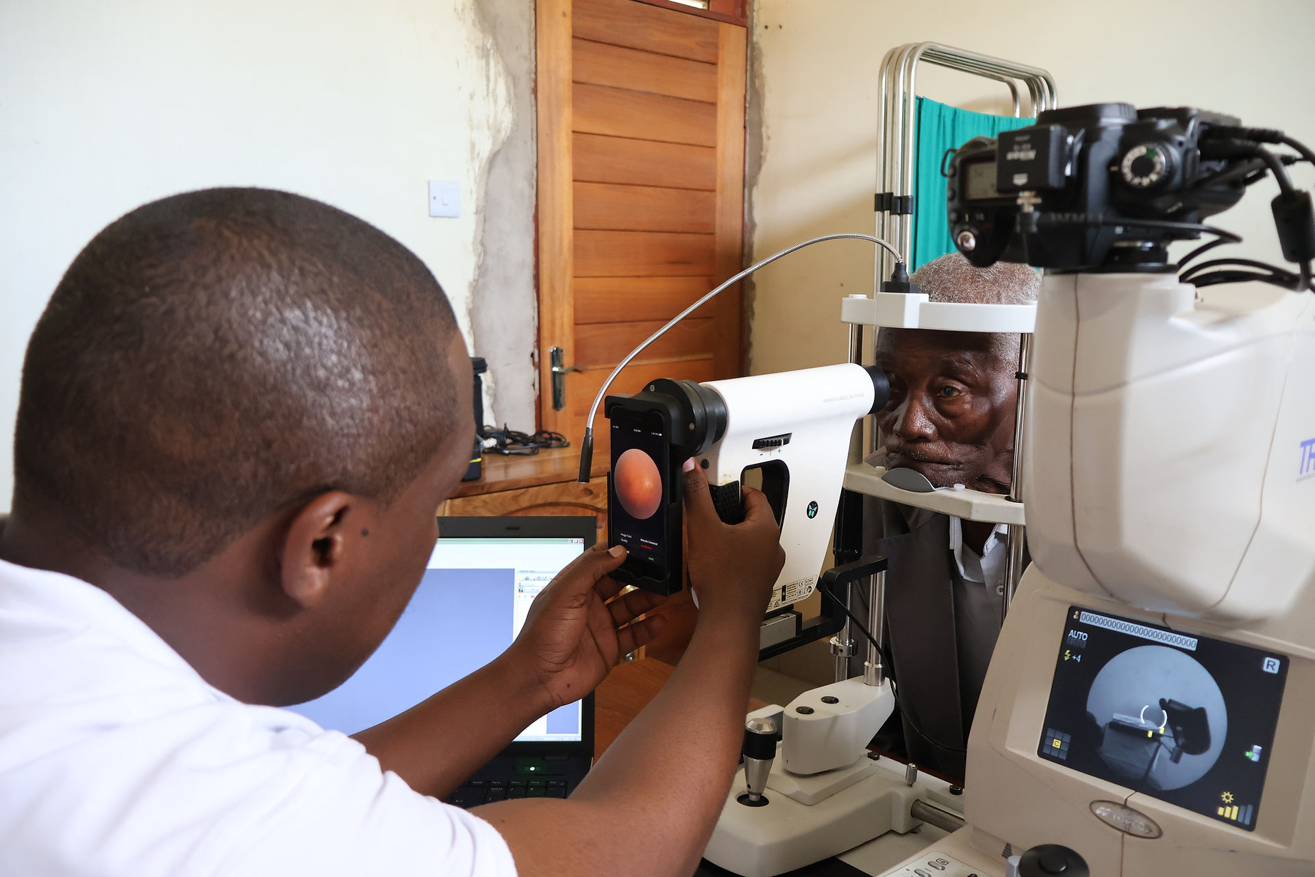 Clinical staff members takes a retinal image of a patient