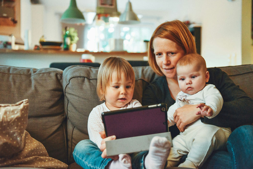 a woman and two small children looking at an ipad