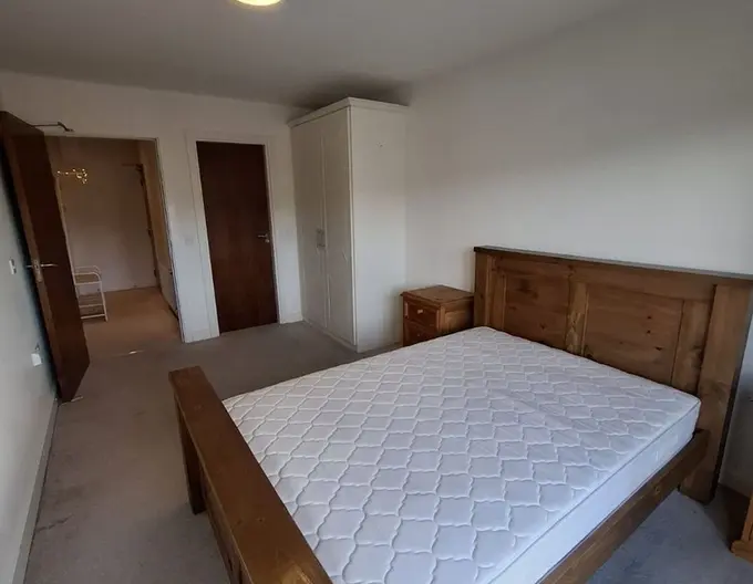 Bright bedroom in Apartment 7 Downview, Cork City, includes a bed and dresser, ideal for a potential buyers.