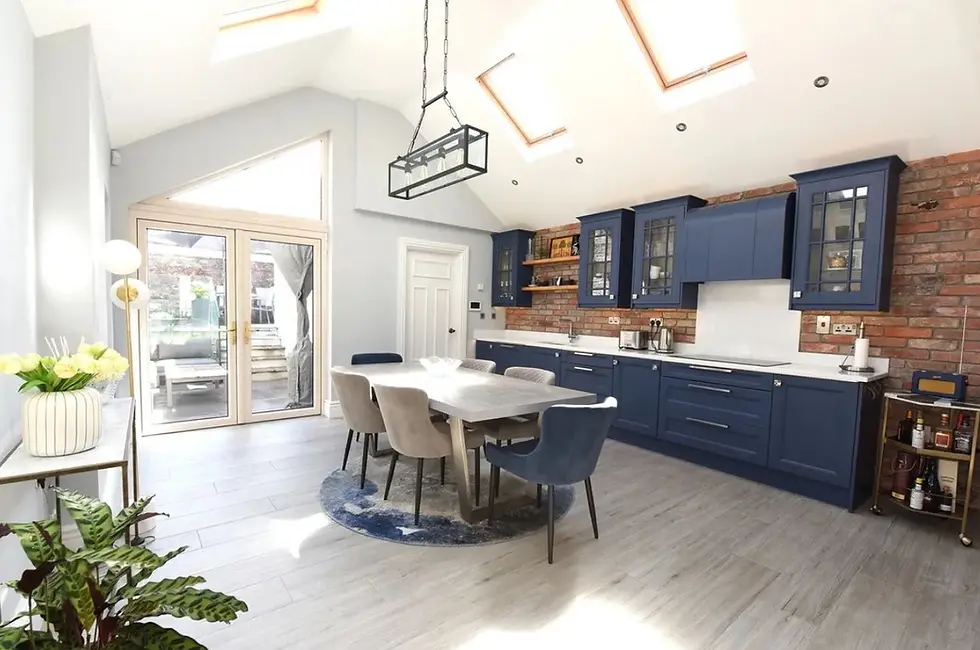 A bright and spacious modern kitchen with blue cabinets and white countertops, and a large kitchen table in a home on Military Hill, Cork City.