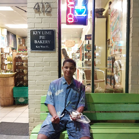 A teenager enjoying his very first frozen chocolate-dipped Key Lime Pie on a stick outside the historic Key Lime Pie Bakery in Key West.