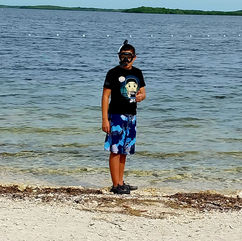 A teen giving thumbs up in snorkel gear, heading into the water at John Pennekamp Coral Reef State Park