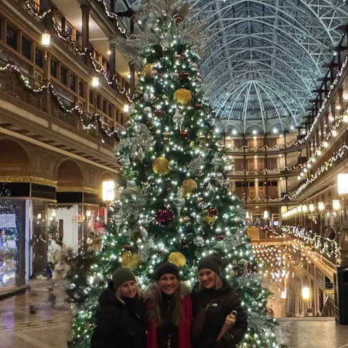 Mara & friends celebrate Christmas in front of the giant decorated tree in the historic Arcade in Cleveland.