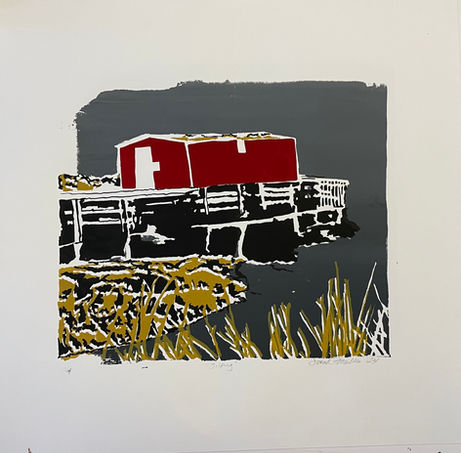 A crooked red fishing stage is balanced on a pier.  There is yello grass in the foreground