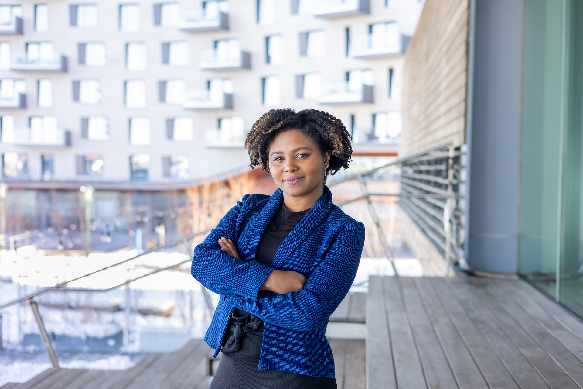 Young Black woman in a blue blazer with her arms crossed at the ICA Boston