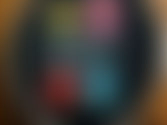 Pac-Man characters cross stitched onto black fabric with a wooden hoop