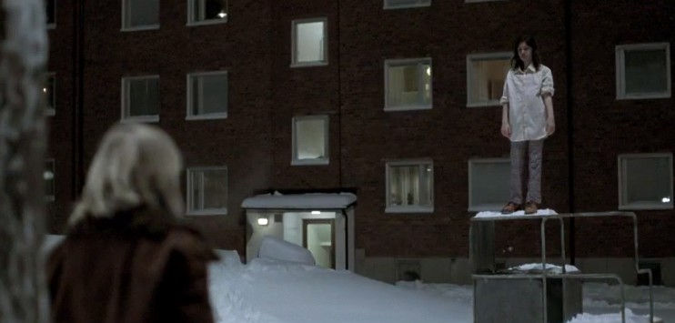 Two children stand in the snow at night