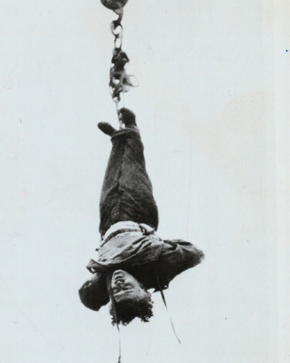 A man hangs suspended by his feet