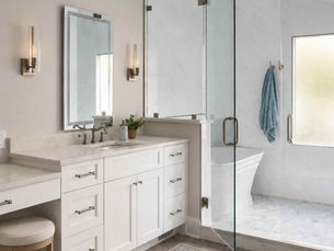 Explore a Cornelius bathroom remodel featuring custom-height vanities and a linen cabinet with built-in laundry hampers. Discover the benefits of custom bathroom cabinetry.