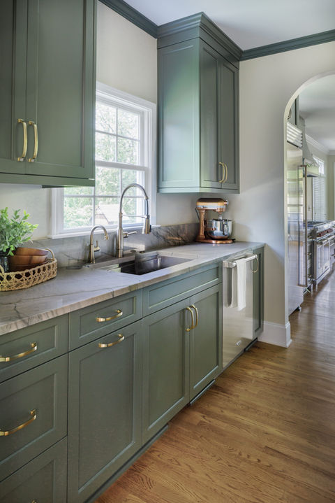 Green scullery with new quartz countertops, arch walkway, and countersplash in Mooresville NC. Built by general contractor Turner Design Build.