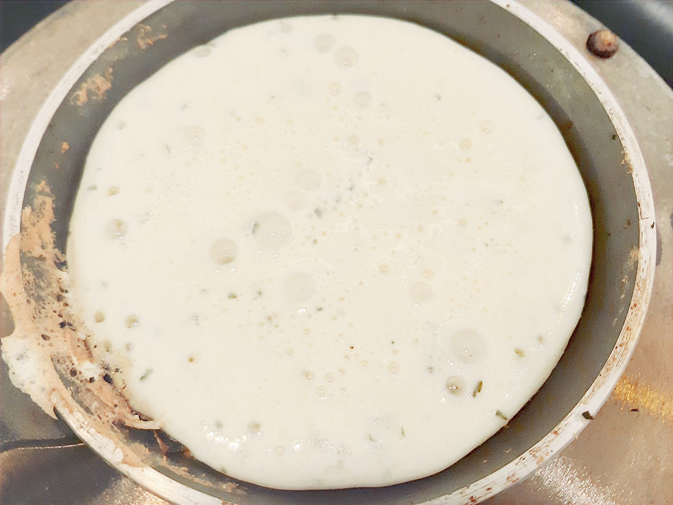 Pâte à blini en train de cuire dans une poêle