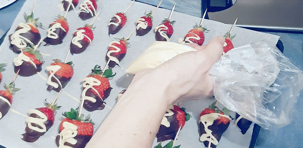 Fraises enrobées de chocolat noir décorées au chocolat blanc avec une poche à douille