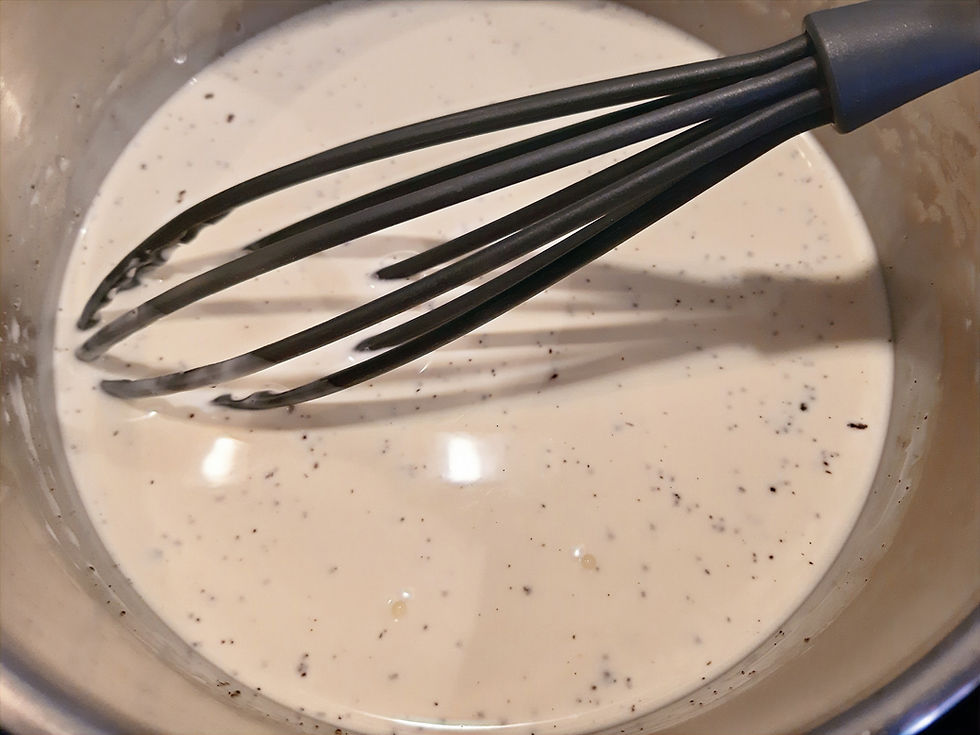 Crème liquide dans une casserole infusée avec des graines de vanille