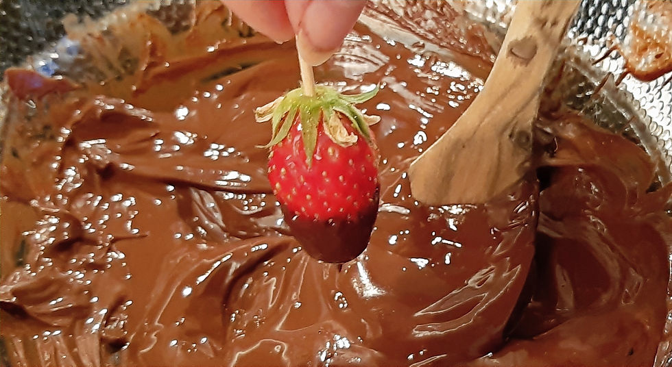 Fraise trempée dans un bol de chocolat noir fondu