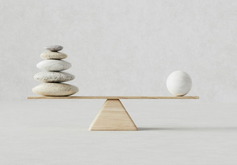 Balanced seesaw with stacked stones on one side, single sphere on other