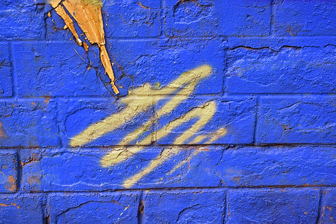 Blue brick wall with white and green spray paint_edited.jpg