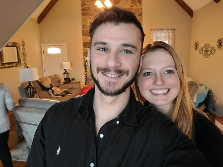 man and woman smiling in a fully furnished house.