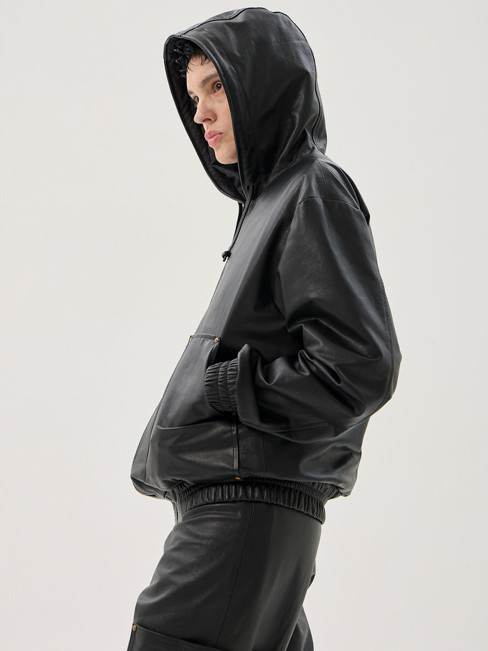 Black calfskin relaxed fit hooded jacket with zip front, large utility pockets and elastic trim
