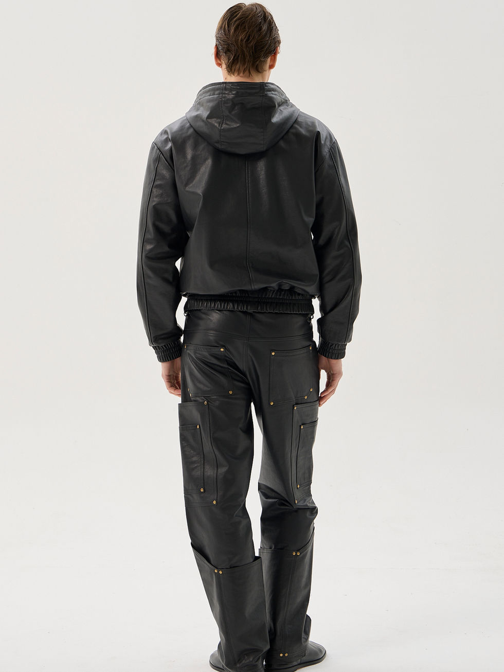 Black calfskin relaxed fit hooded jacket with zip front, large utility pockets and elastic trim