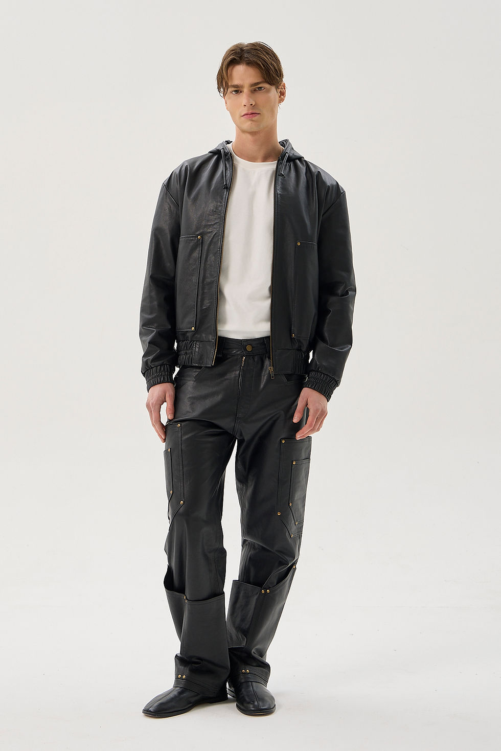 Black calfskin straight leg cargo trousers with reinforced utility pockets and brass rivets