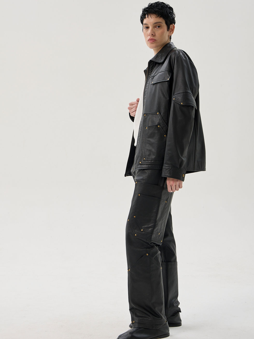 Black calfskin straight leg cargo trousers with reinforced utility pockets and brass rivets