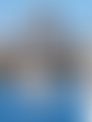 Boat on the water with Vic West waterfront condos and blue sky in the background.