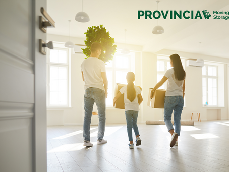 Moving Day Tips Blog Image: A couple and their daughter with boxing boxes and a tree moving in to their new home