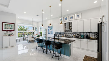 Modern white kitchen with oversized island photographed by Edwin Figueroa Photography.